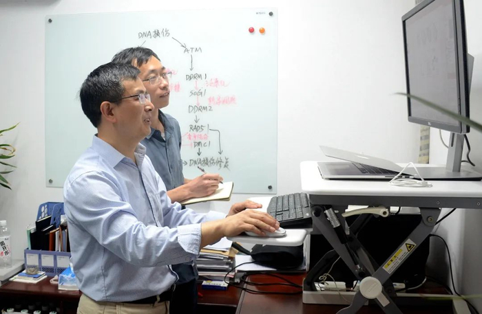 ▲严顺平与博士后王轩鹏讨论论文撰写（匡敏 摄）