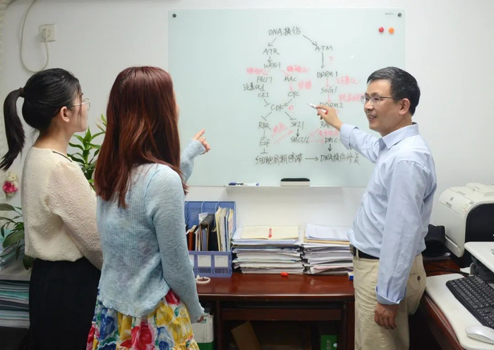 ▲严顺平老师与学生一起在白板上“探案”（匡敏 摄）
