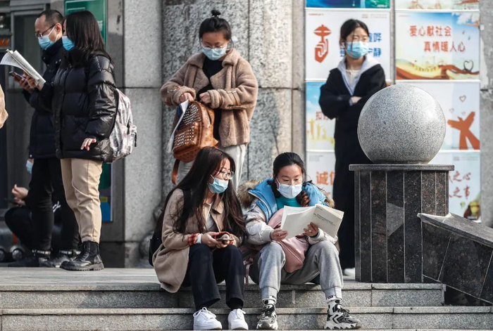 教师资格证考试前，考生们在考场外复习（图 | 视觉中国）