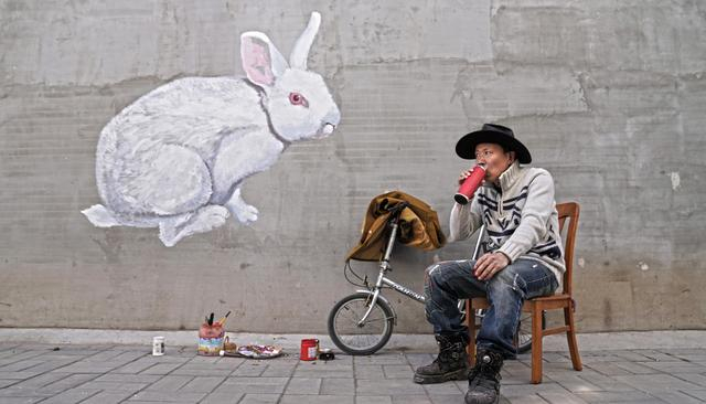 3月27日，驻村艺术家郑志岩在居民家外墙上做墙绘。新京报记者 陈杰 摄 