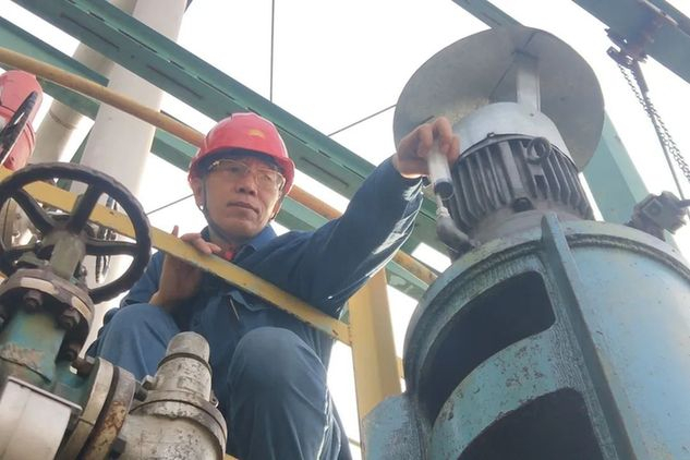 ▲用自制补油器给设备加油的刘立威。