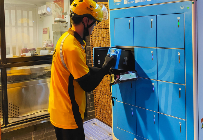 外卖小哥正在使用换电柜 图/视觉中国