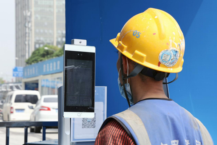 4月22日，一位工人在中建八局成都某项目云筑防疫一体机前刷脸