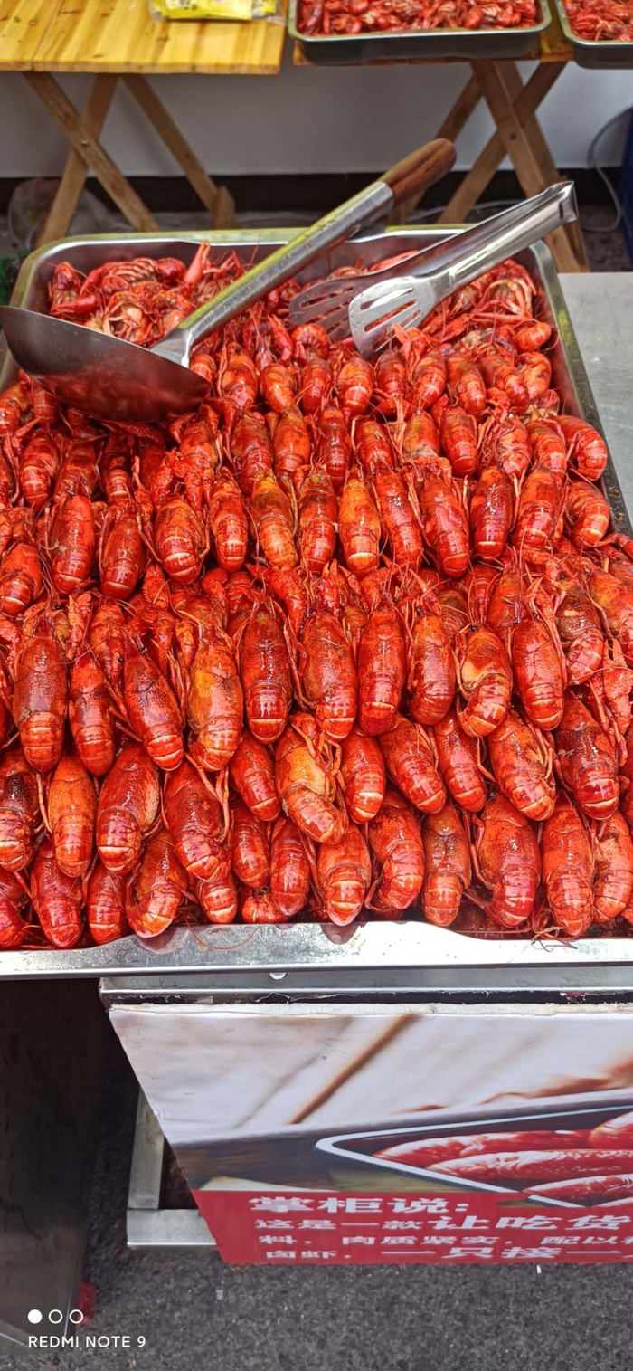     小欢喜小龙虾馆门口摆放着成品菜肴（摄影：肖伟）