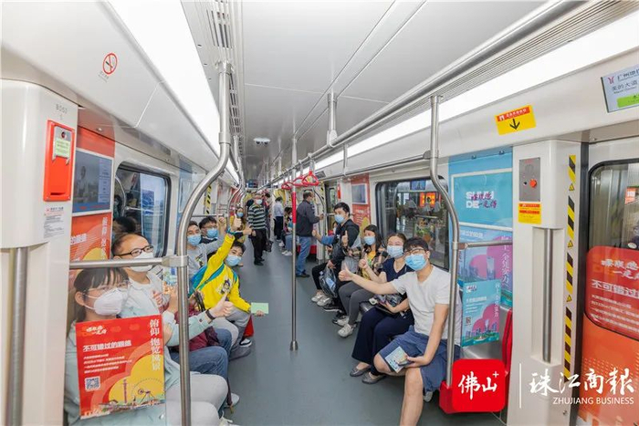 搭乘广州地铁七号线西延顺德段的市民在顺德主题专列上点赞合影。周焯杰/摄