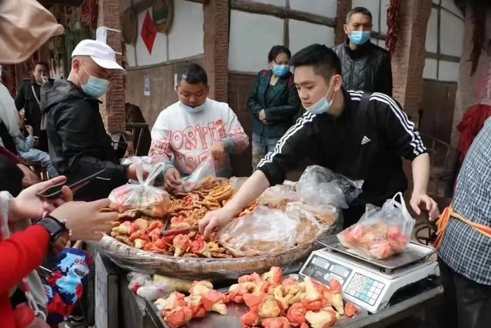 （图为在自己门口开店的海龙村村民）