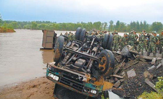 ▲抢险人员用卡车等物封堵导致溃水事故的决口（资料图）