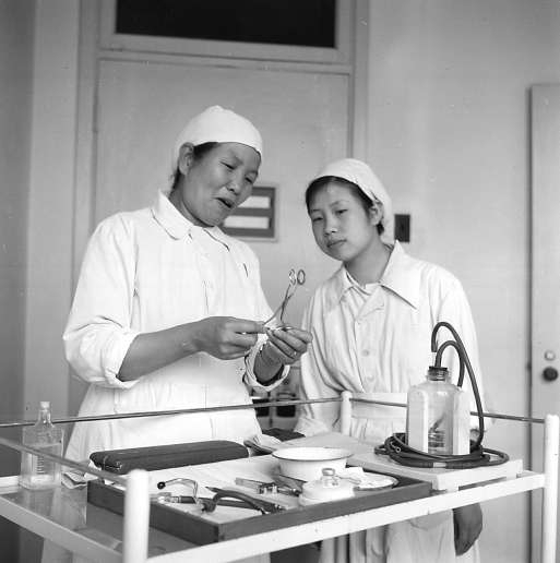 　　1958年，积水潭医院护士长毕华英指导年轻护士做术前准备。 冯文冈/摄