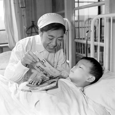 　　1963年，北京儿童医院腹部外科护士长袁桂英在护理病人。冯文冈/摄