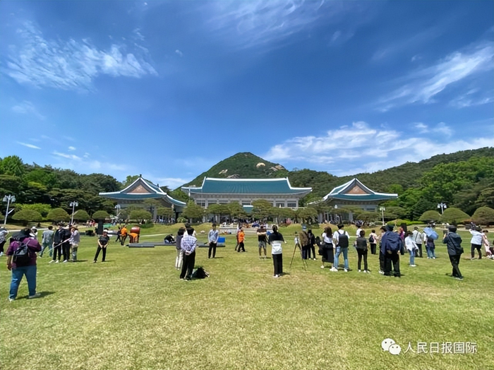 民众在青瓦台本馆前的草坪上合影留念。马菲摄