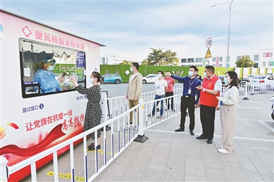 为构建15分钟核酸“采样圈”，江苏省无锡市锡山区设立多个便民核酸采样小屋。图为近日，该区纪检监察干部在鹅湖镇甘露社区广场核酸小屋前了解相关情况。黄佳明 摄