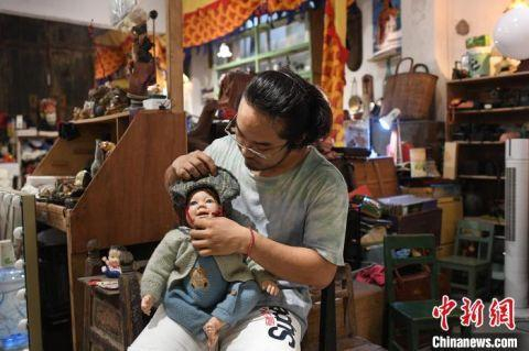 图为武楷斯和自己喜欢的娃娃合影 中新社记者陈楚红 摄