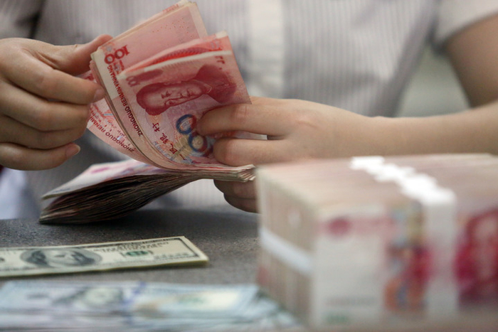 图为一家银行的工作人员清点人民币和美元。新华社发