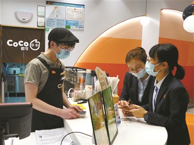     建行宁波市分行在阪急商圈实现数字人民币全覆盖，工作人员指导商户使用数币收款。