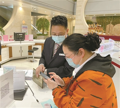     中行宁波市分行营业部大厅内，工作人员指导市民开设数字人民币钱包。