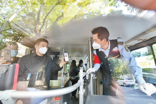 公交司机在乘客上车时查验健康码。 本报记者 邓伟 摄