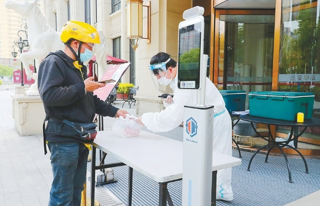 5月16日，外卖骑手在上海市宝山区一家饭店门口取餐准备派送。新华社记者 方喆 摄