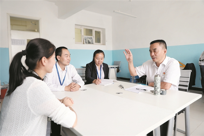     邱成国（右一）与华山中学教师进行交流（资料图片）。    邱成国  提供