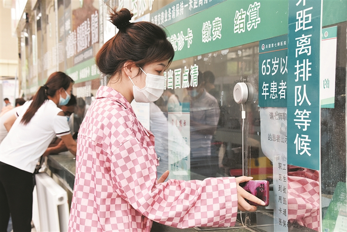     5月23日，七师医院综合楼门诊收费大厅内，前来就医的群众在办理缴费业务。李瑞强  摄