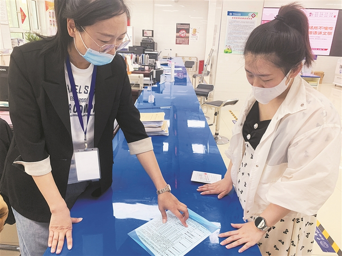     5月20日，八师石河子市医疗保障事业管理中心工作人员（左）为职工宣传医保政策。糟鹏  摄