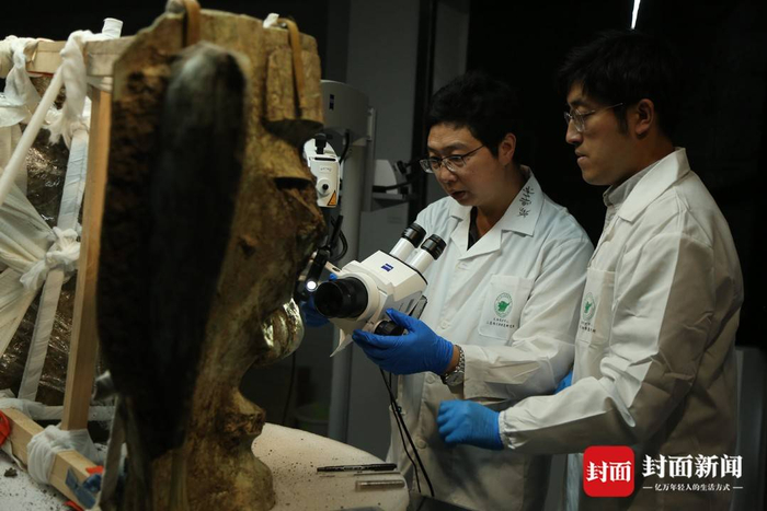 文保专家对青铜大面具进行清理检测（四川省文物考古研究院供图）