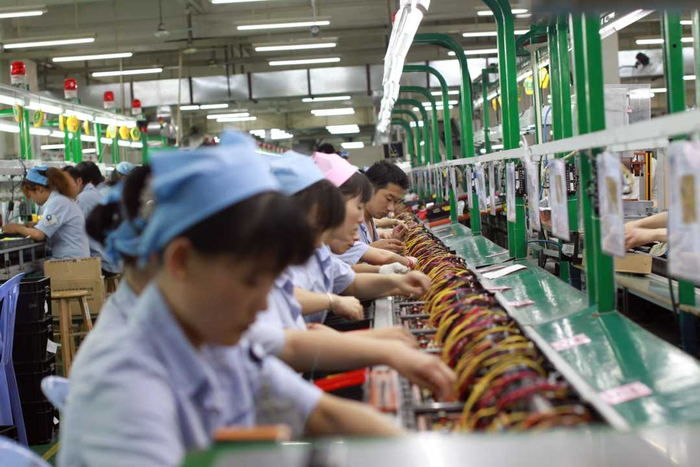 图为深圳市航嘉驰源电气股份有限公司插件组工人正在作业。王青松摄