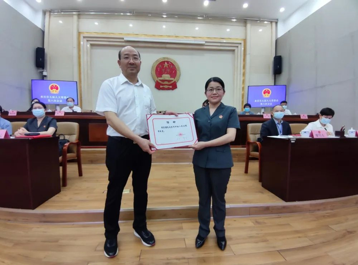 韦平向新任命同志颁发任命书。