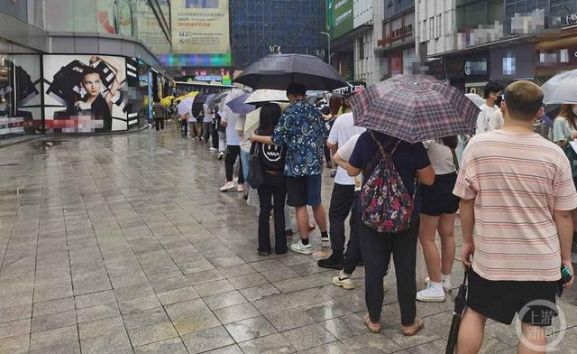 在观音桥不少人冒雨排队。    图片来源：上游新闻记者摄