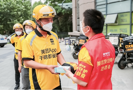 　　▲党员骑手带头发放物资。摄影人:安龙