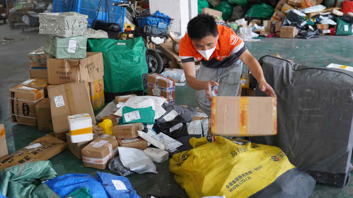 6月8日，上海市闵行区一处快递网点，一名快递员在进行包裹分拣。新华财经记者 杨有宗 摄