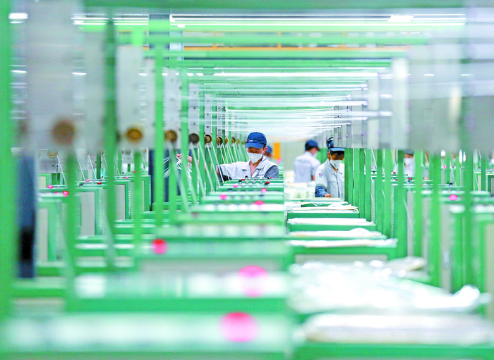 ▲生产车间内，工人们专注地操控作业