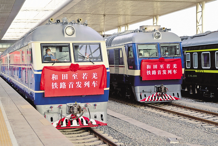     6月16日，和若铁路首趟旅客列车（左）和货运列车在新疆和田火车站等待发车。新华社记者 丁 磊摄