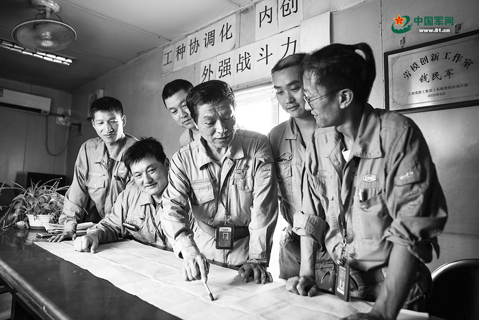 江南造船总装一部现场工程师钱民军（右三）和同事们探讨业务工作。作者供图 