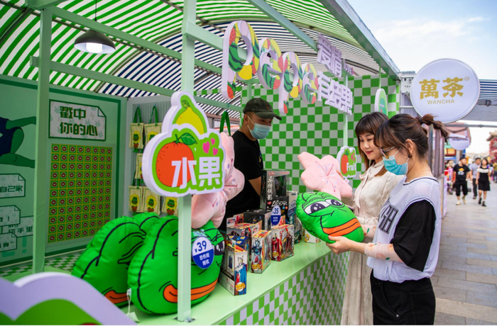 2022年6月18日晚，呼和浩特市玉泉区，游客在塞上老街区块一家快闪店选购小吃。