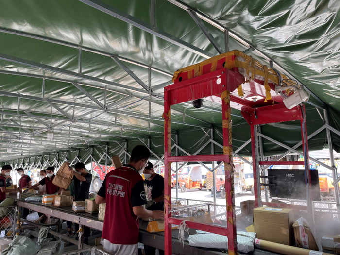 北京东风公园附近申通快递中转站生产线消毒分拣快递 本报记者/摄