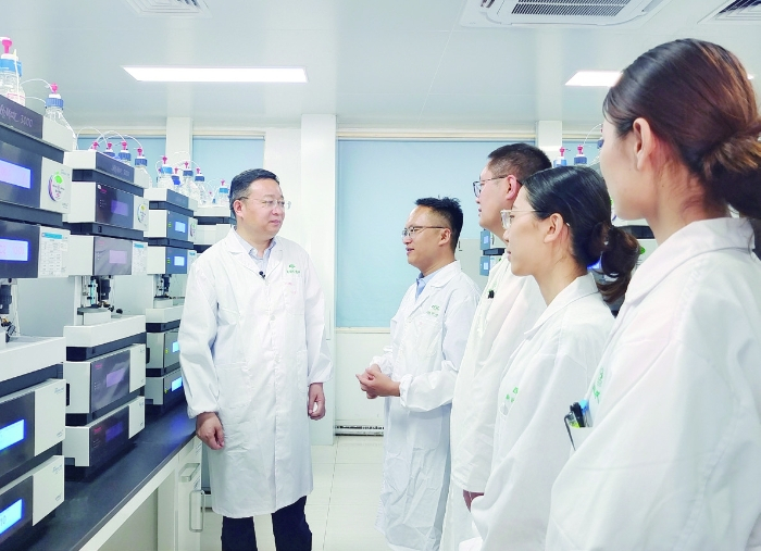 图①：张贵民在鲁南制药国际药品研发中心了解项目进展情况。