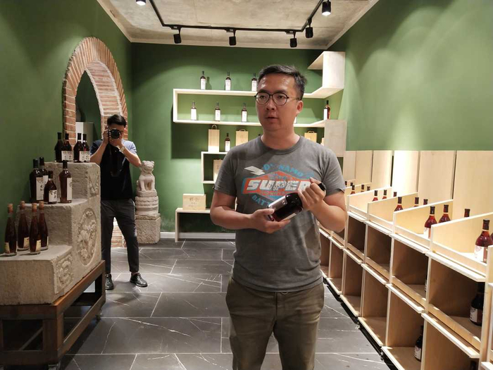 朱海洋正在向记者展示樱韵系列樱桃酒。宋美倩摄