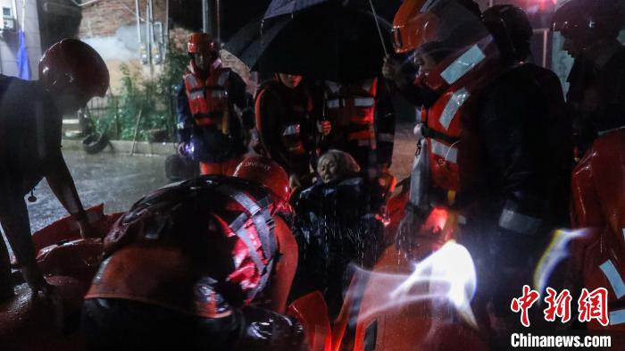 图为6月13日，救援人员在长汀县童坊镇红明村转移群众。李袁辉摄