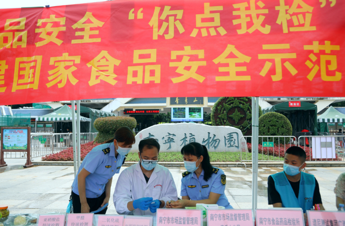 南宁市食品药品检验所工作人员对群众送来的紫苏、黄瓜皮、油麦菜等样品进行免费检测。（何正君 摄）