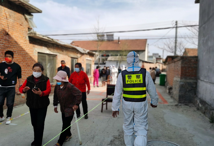 4月28日，辽宁丹东边境管理支队马市边境派出所民警在社区核酸检测现场维护秩序 图源：视觉中国 