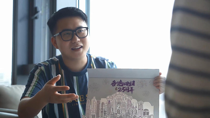 　　香港青年李芃澄为客户介绍产品