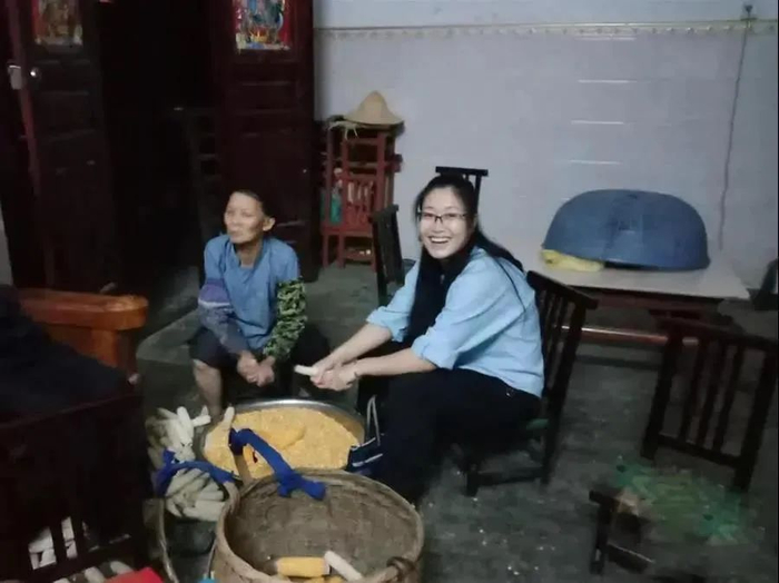 黄文秀到村民家走访，主动帮村民掰玉米