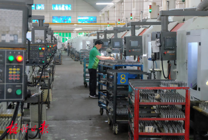 三禾添佰利五金加工有限公司工作人员在车间里看管机械加工过程。陈凡 摄（资料图片）