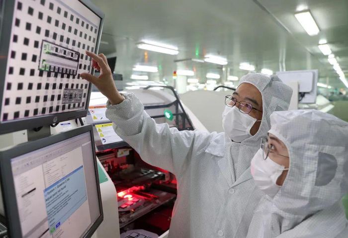 △ 吴剑旗院士与技术人员探讨微波组件自动化集成工作。