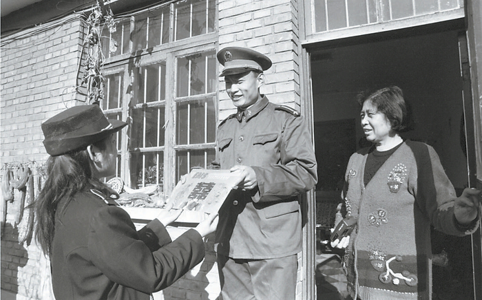 　　上世纪90年代，每天有300余辆EMS快递车穿梭于京城的大街小巷。图为快递员（左一）送件上门。