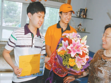 　　2009年7月8日，北京市邮政物流公司快递员将当年首张高考录取通知书送到景山中学考生戴高乐手中。 方非/摄