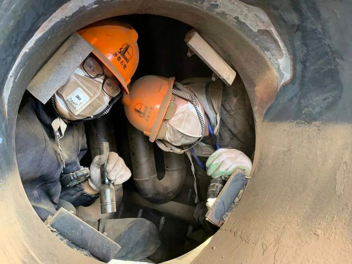 工作人员在受限空间设备内进行检维修作业。