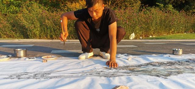 翟云川在长江边作画。图/九派新闻 马婕盈