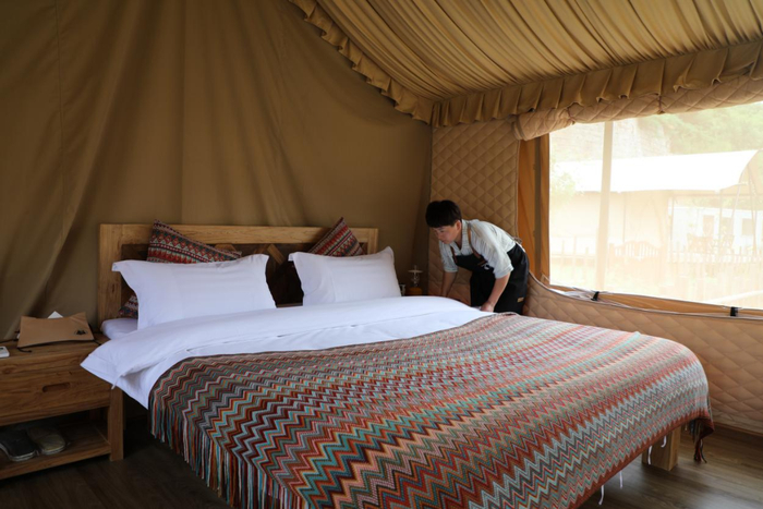 野三坡露营基地的管家正在整理床铺，迎接游客的到来。