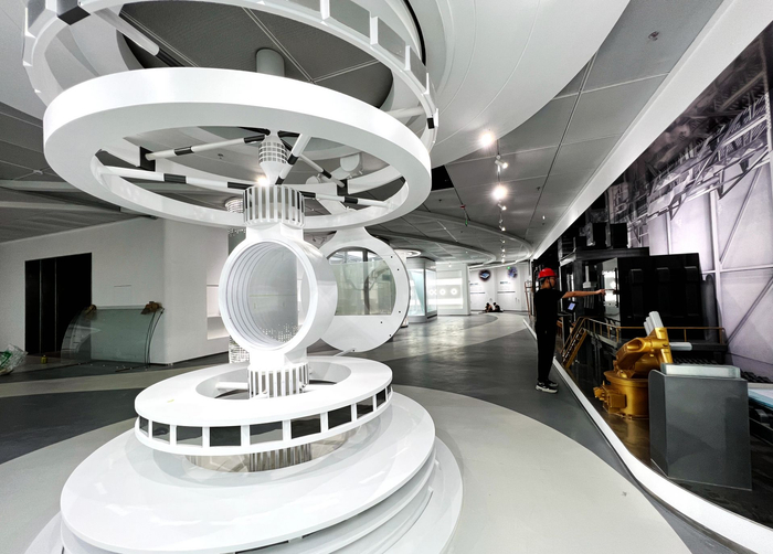 技术人员对展区内的互动展品进行调试